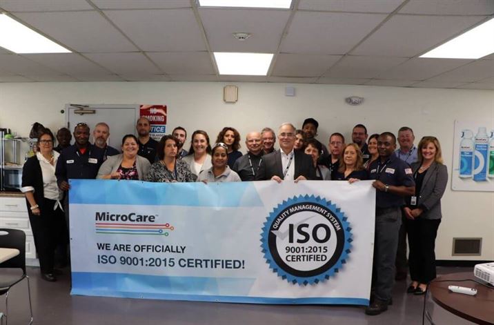 El equipo de MicroCare con el cartel de la certificación ISO en 2018