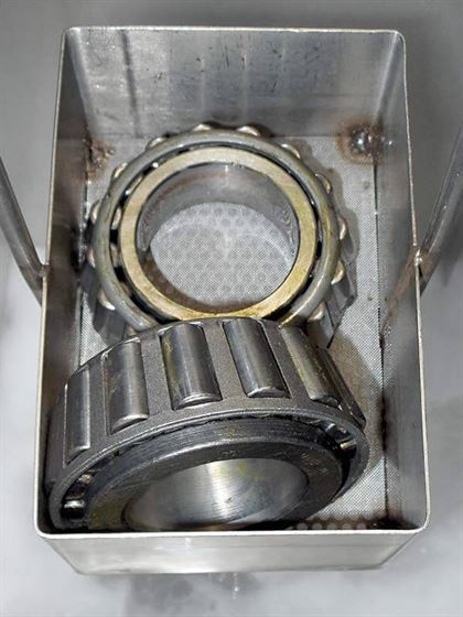 These two bearing are part of a military helicopter, and they are being degreased in a MicroCare cleaner during depot maintenance