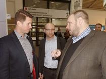 Scott Wells, MicroCare Sales Manager for Europe, speaks with two visitors from Slovakia