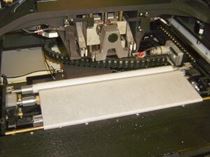 The understencil wiping roll, installed on an MPM UP2000 printer. The roll is draped over the vacuum and wetting bars